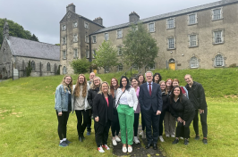 group of students stand together outside an historic building in Ireland